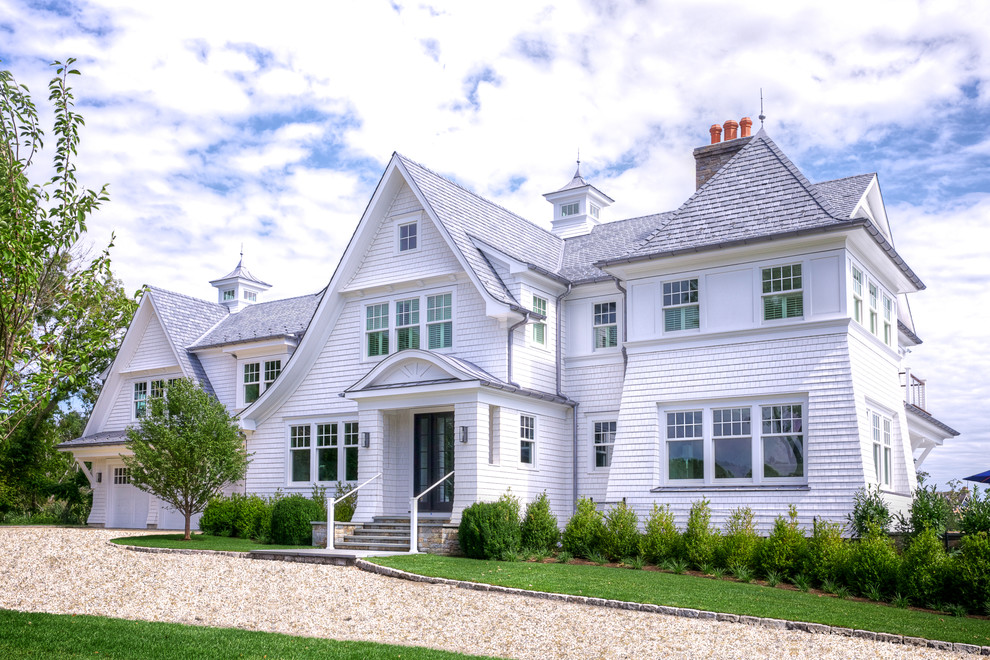 Imagen de fachada de casa blanca costera grande de dos plantas con revestimiento de madera, tejado de teja de madera y tejado a cuatro aguas