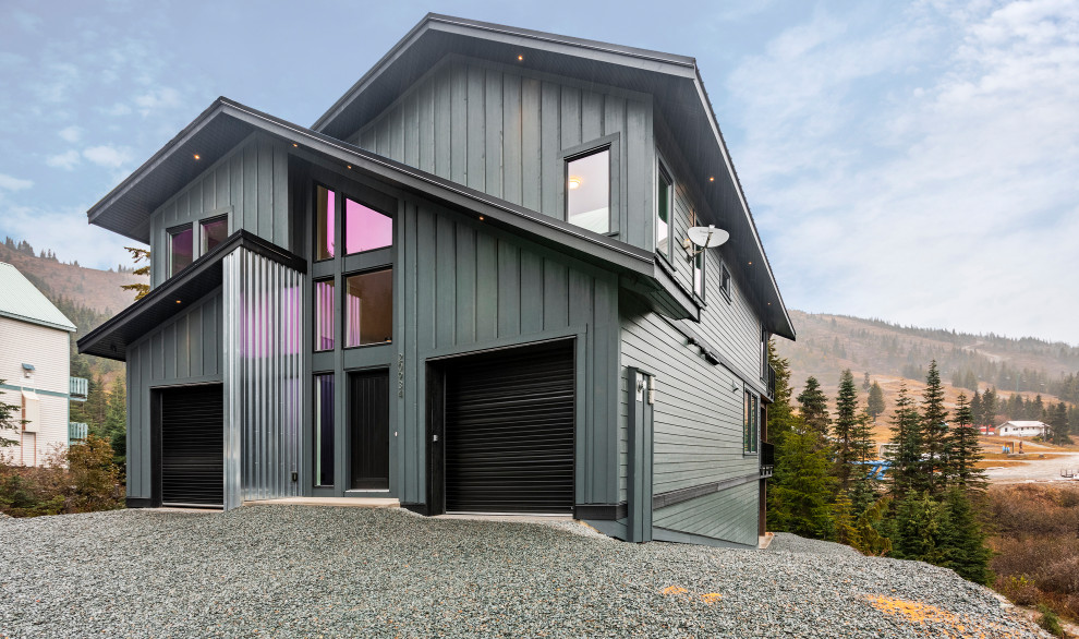 Imagen de fachada de casa gris moderna extra grande de tres plantas con revestimientos combinados, tejado a dos aguas y tejado de metal