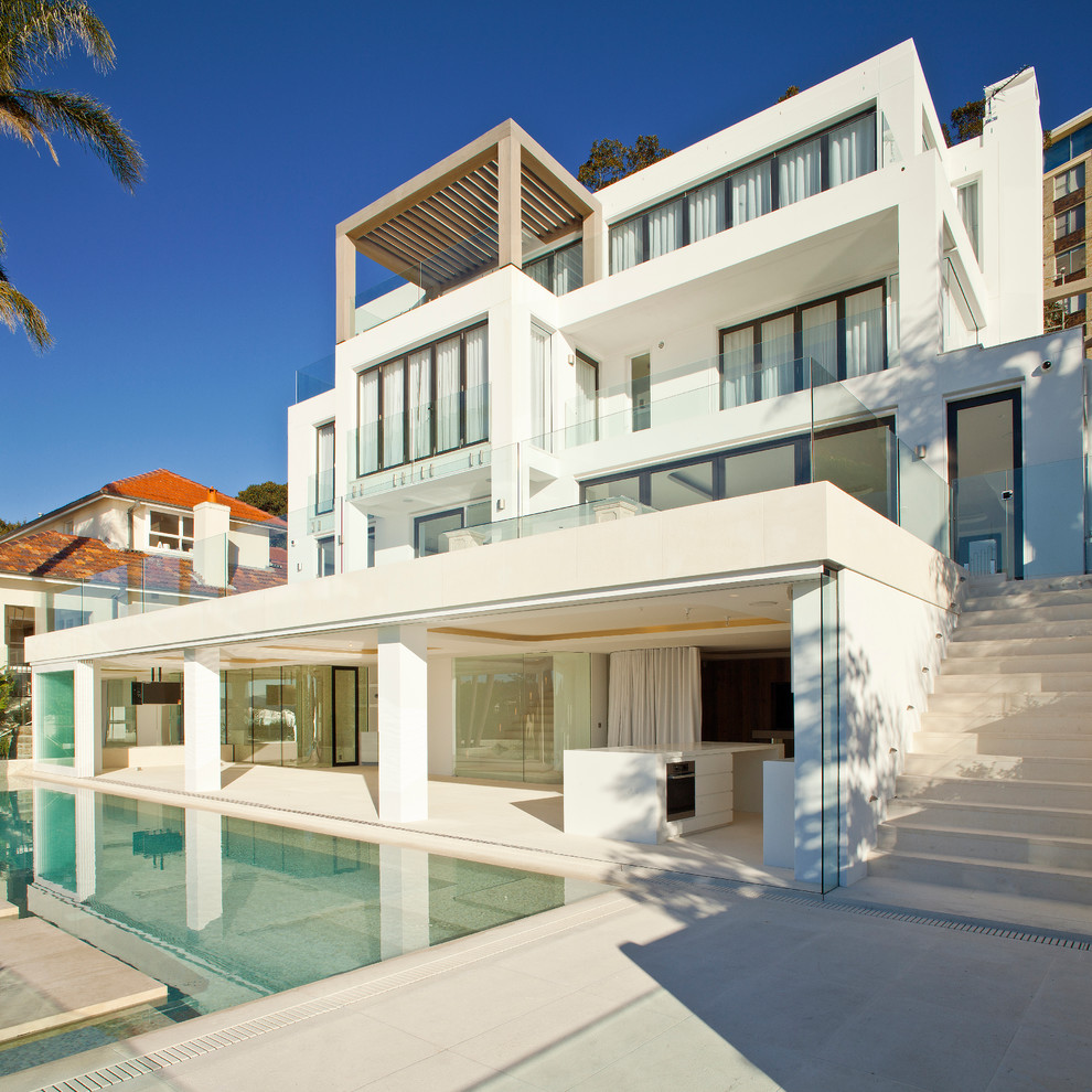 Источник вдохновения для домашнего уюта: трехэтажный, большой, белый дом в средиземноморском стиле с плоской крышей