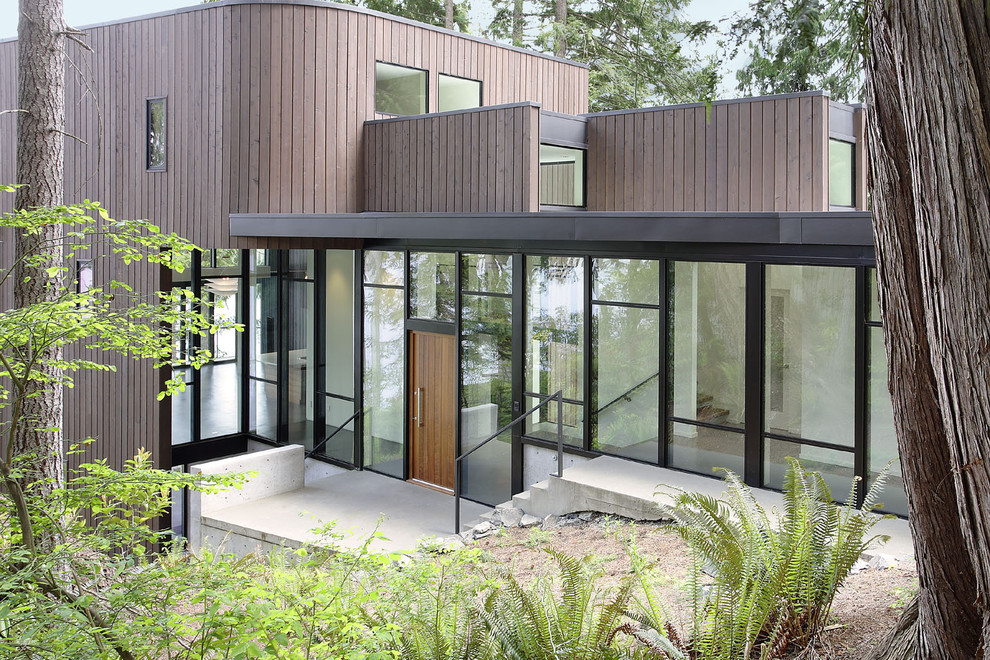 Réalisation d'une façade de maison grise minimaliste en bois à un étage et de taille moyenne.