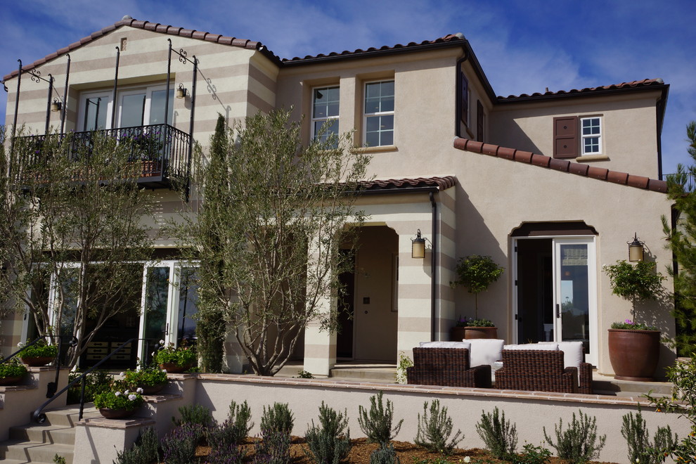 Large tuscan beige two-story stucco exterior home photo in San Diego