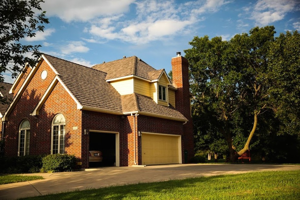 Large transitional beige two-story brick gable roof photo in Wichita