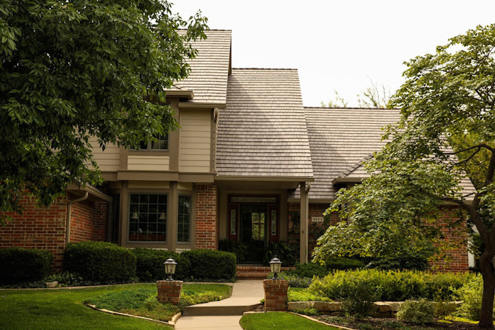 Ejemplo de fachada de casa marrón minimalista grande de dos plantas con revestimiento de ladrillo, tejado a cuatro aguas y tejado de teja de madera
