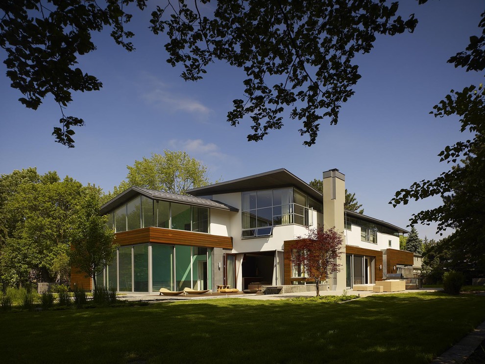 Aménagement d'une très grande façade de maison blanche contemporaine en bois à un étage avec un toit en appentis.