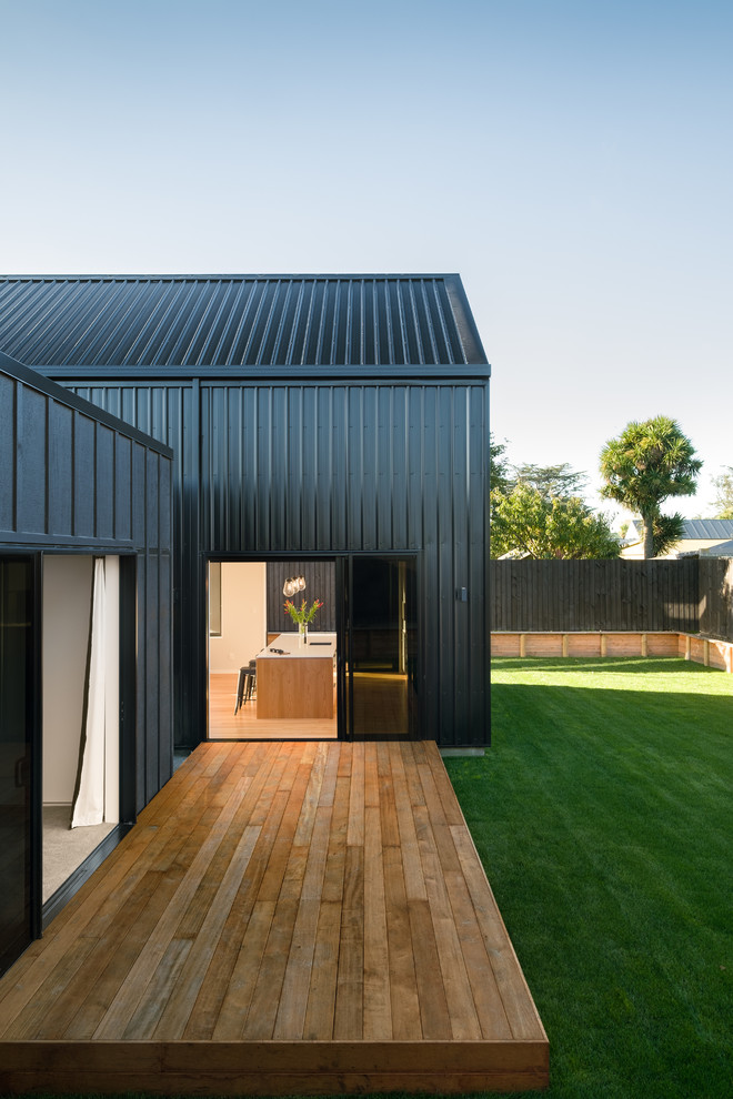 Imagen de fachada de casa pareada negra costera pequeña de dos plantas con revestimiento de madera, tejado a dos aguas y tejado de metal