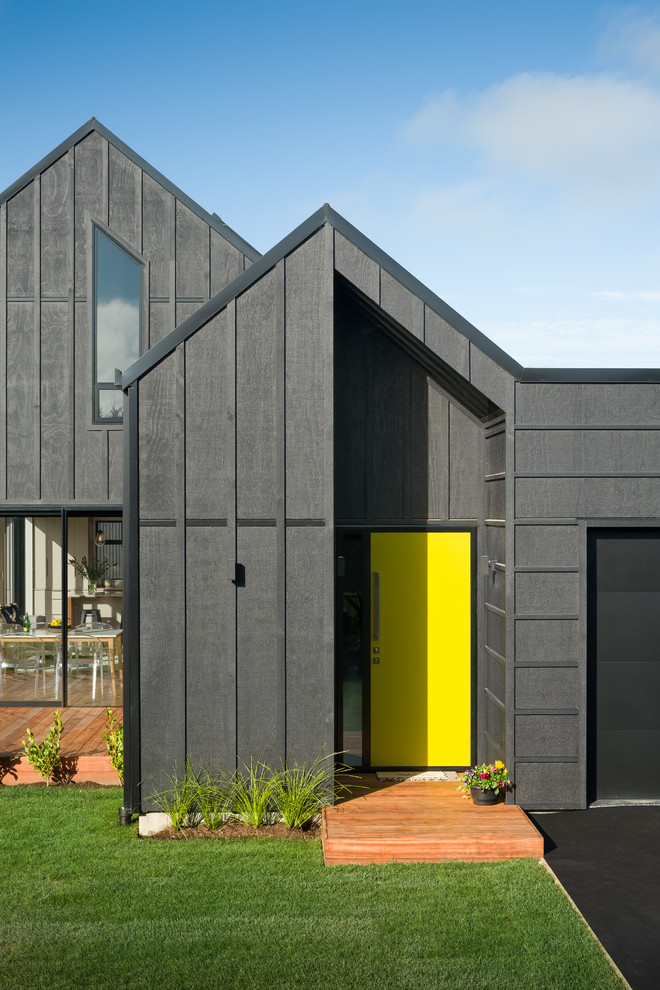 Diseño de fachada de casa pareada negra marinera pequeña de dos plantas con revestimiento de madera, tejado a dos aguas y tejado de metal