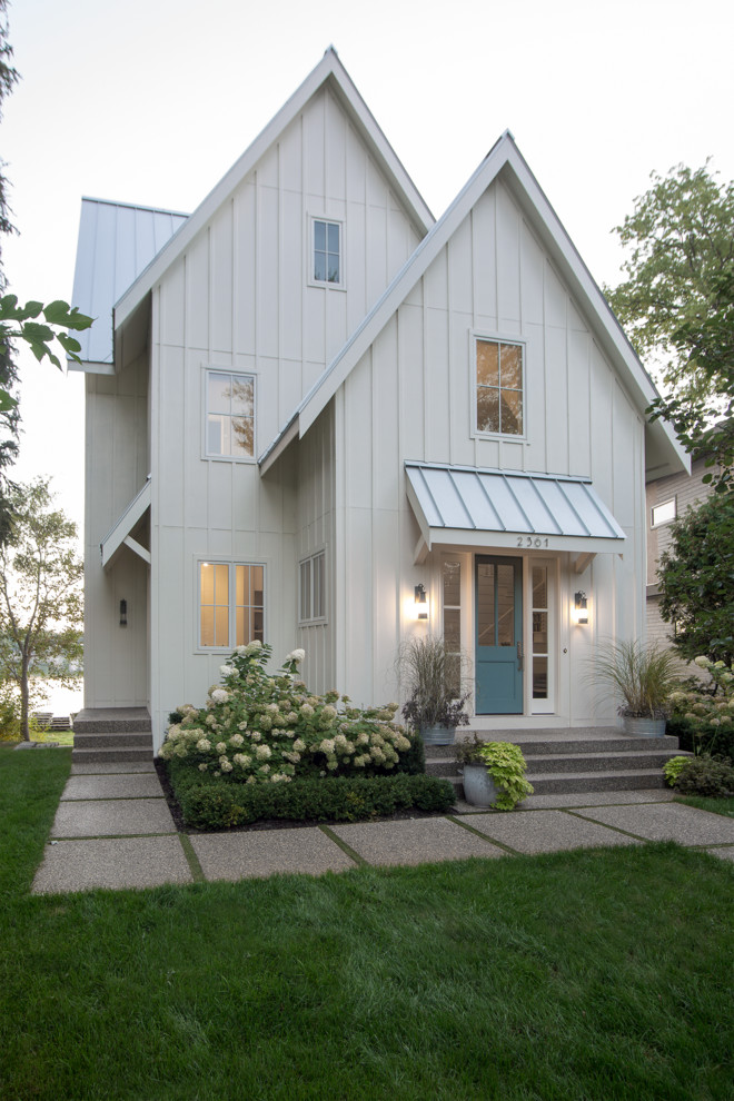 Idées déco pour une façade de maison blanche classique avec un toit à deux pans.