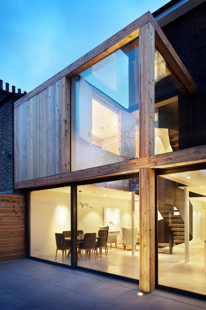 Brown contemporary two floor semi-detached house in London with metal cladding, a flat roof and a metal roof.