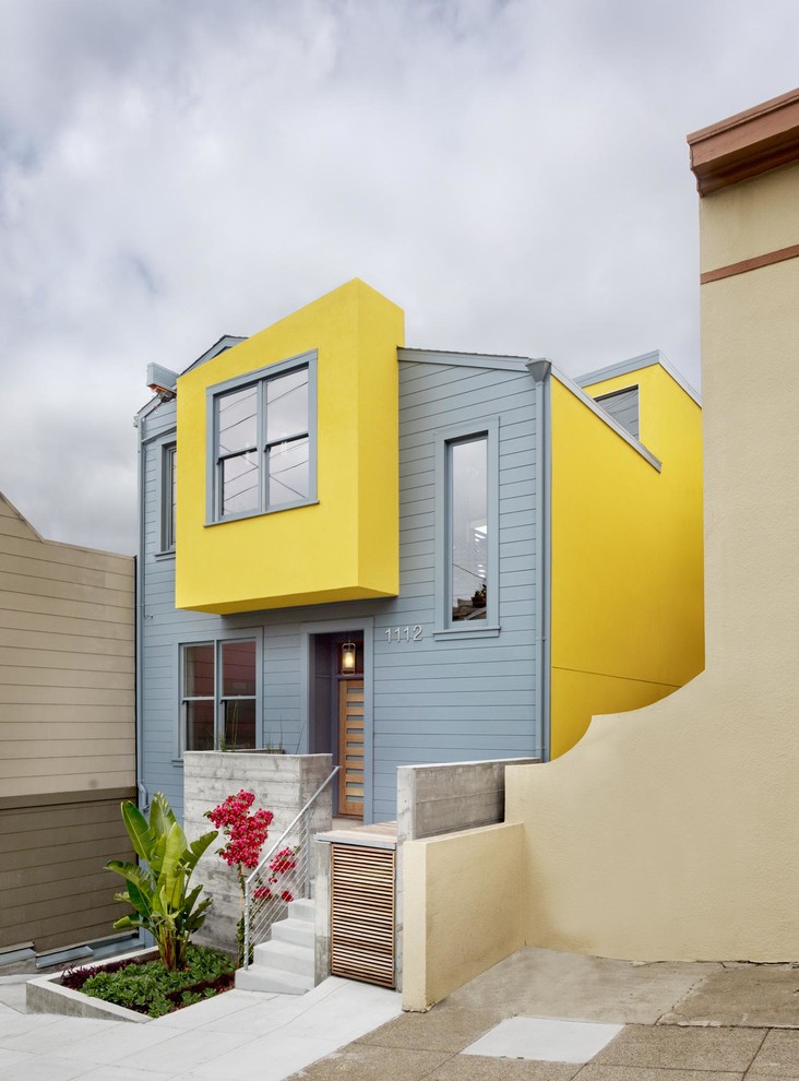 Modelo de fachada de casa multicolor contemporánea de tamaño medio de dos plantas con revestimientos combinados