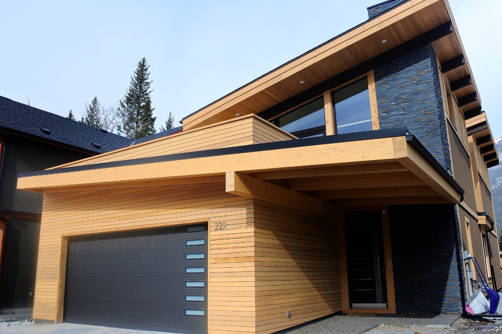 Foto della facciata di una casa marrone moderna a due piani di medie dimensioni con rivestimento in legno
