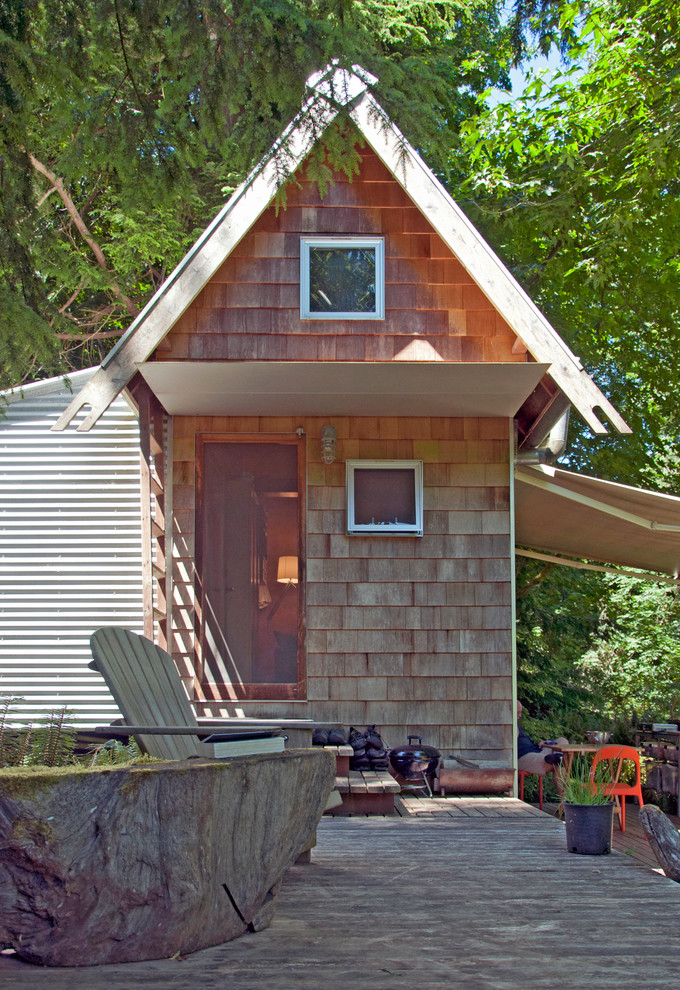 This is an example of a small rustic bungalow tiny house in Seattle with wood cladding and a pitched roof.