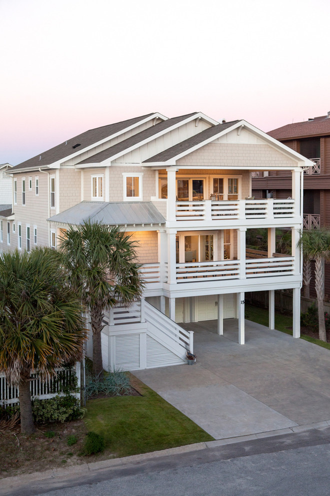 This is an example of a large and beige beach style house exterior in Other with three floors.