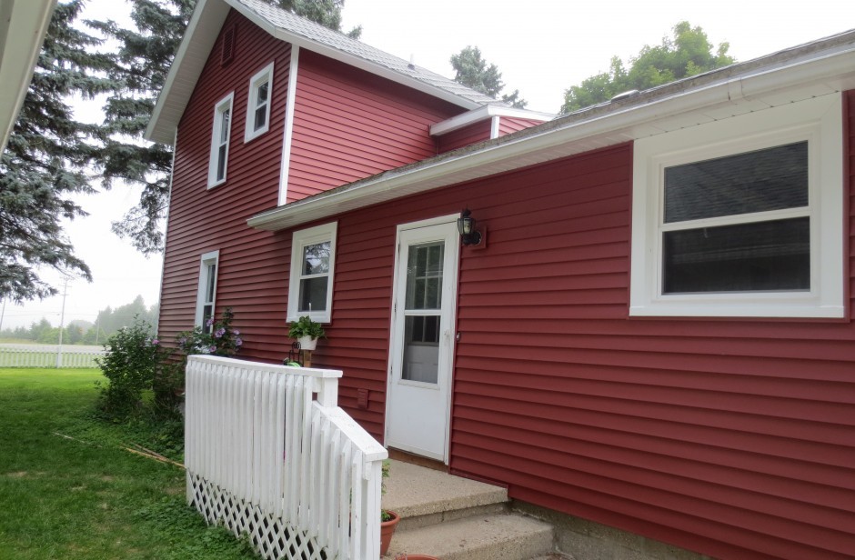 Medium sized and red country two floor detached house in Grand Rapids with wood cladding, a pitched roof and a shingle roof.