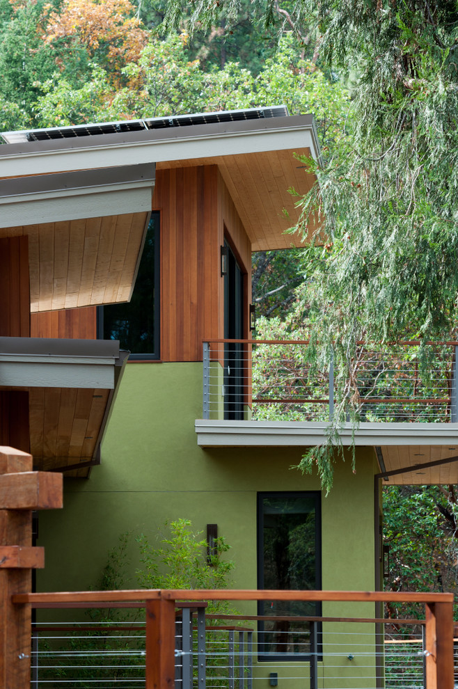 Modelo de fachada de casa verde contemporánea grande de dos plantas con revestimientos combinados, tejado de un solo tendido y tejado de metal