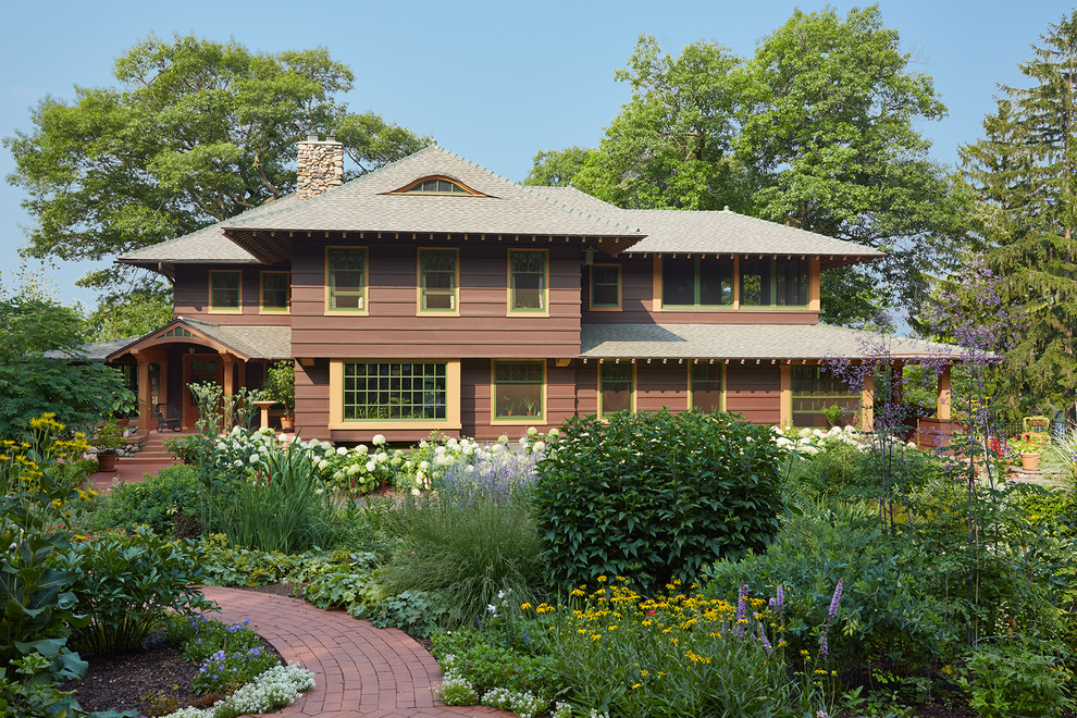 Ejemplo de fachada marrón de estilo americano de dos plantas con revestimiento de madera y tejado a cuatro aguas