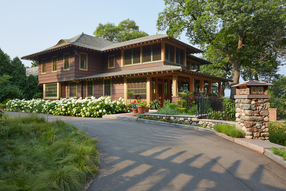 Ejemplo de fachada marrón de estilo americano grande de dos plantas con revestimiento de madera y tejado a cuatro aguas