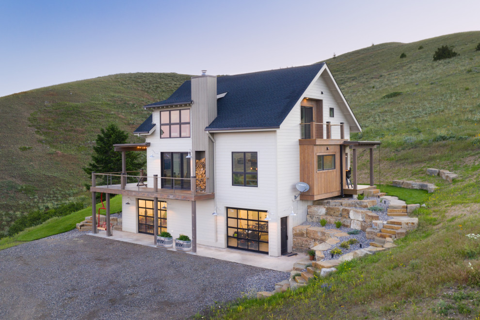 Mid-sized mountain style white three-story wood exterior home photo in Other with a shingle roof and a gray roof