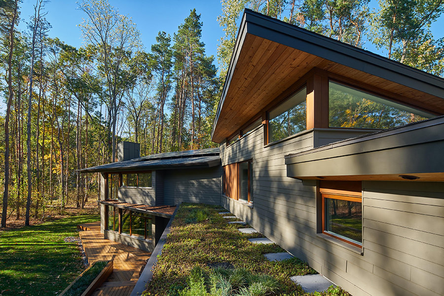 Ejemplo de fachada de casa gris minimalista de tamaño medio de dos plantas con revestimientos combinados y techo verde