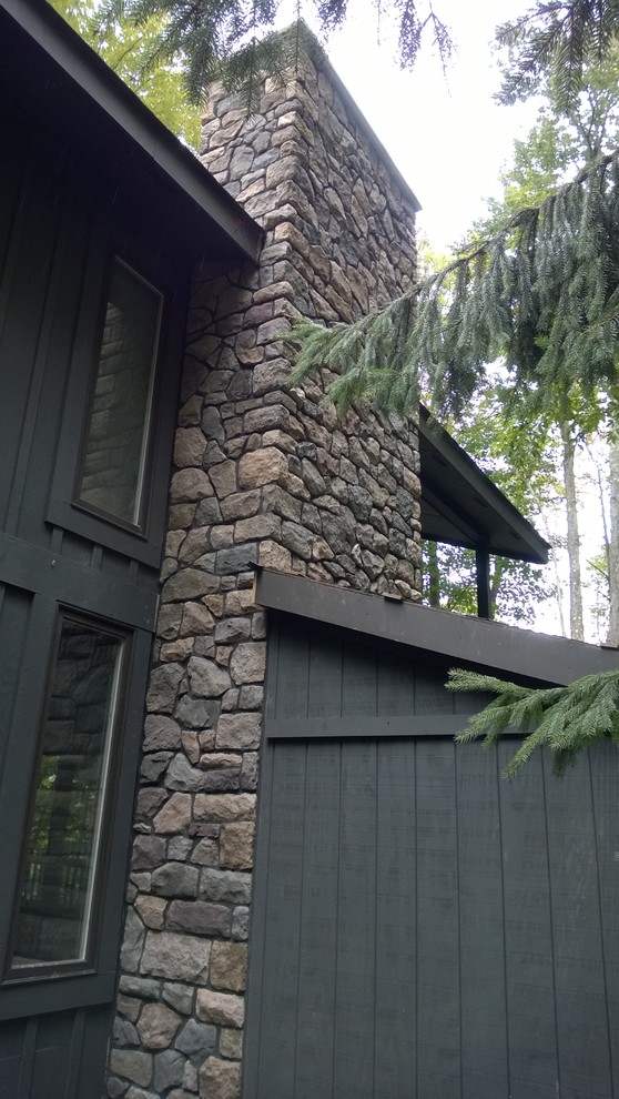 Modelo de fachada de casa gris rústica de tamaño medio de dos plantas con revestimiento de piedra