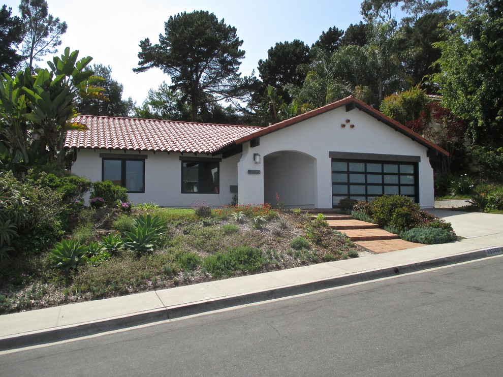 Medium sized and white mediterranean bungalow render detached house in San Diego with a pitched roof and a tiled roof.