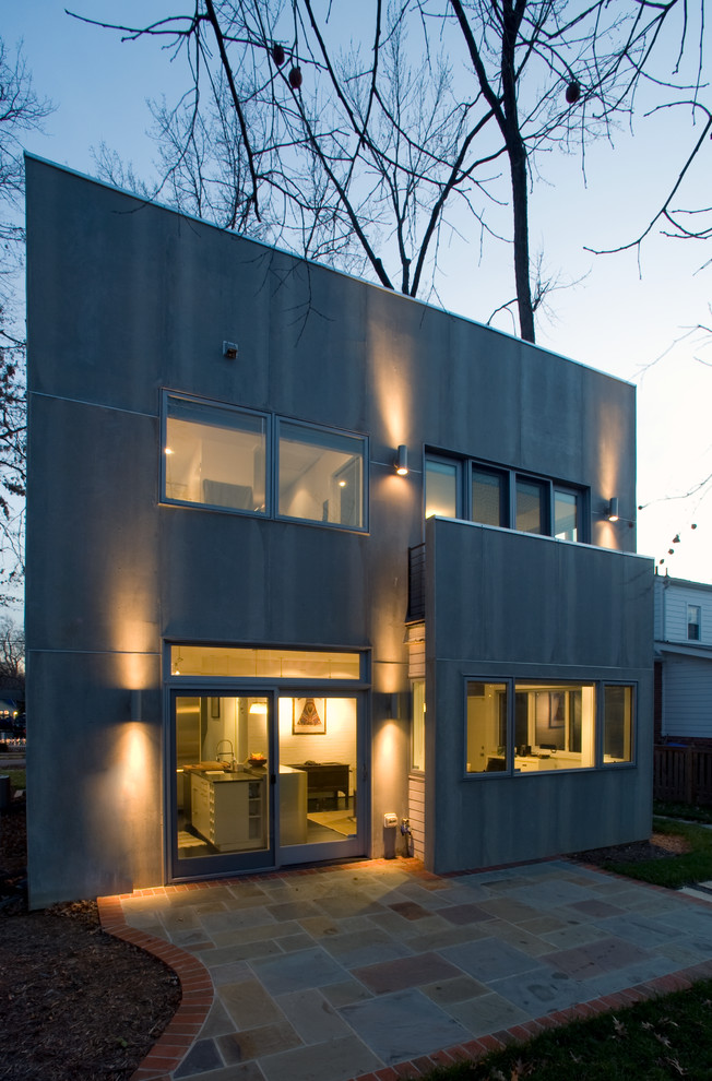 Modern inredning av ett grått hus, med två våningar, blandad fasad och platt tak