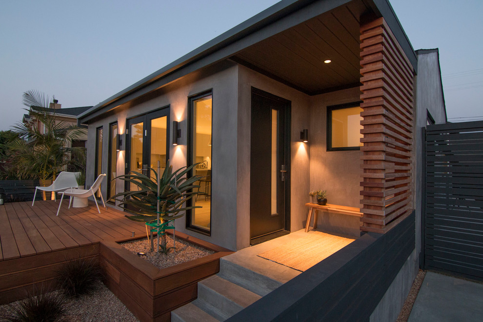 Идея дизайна: маленький, одноэтажный, серый частный загородный дом в стиле модернизм с облицовкой из цементной штукатурки, двускатной крышей и крышей из гибкой черепицы для на участке и в саду