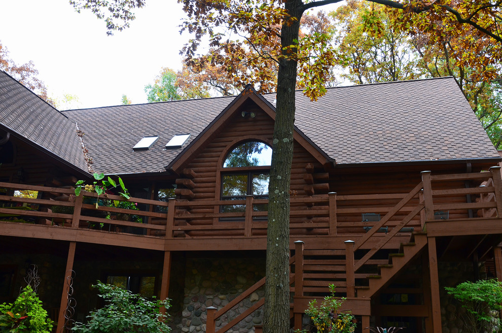 Imagen de fachada marrón rústica de tamaño medio de dos plantas con revestimiento de madera y tejado a dos aguas