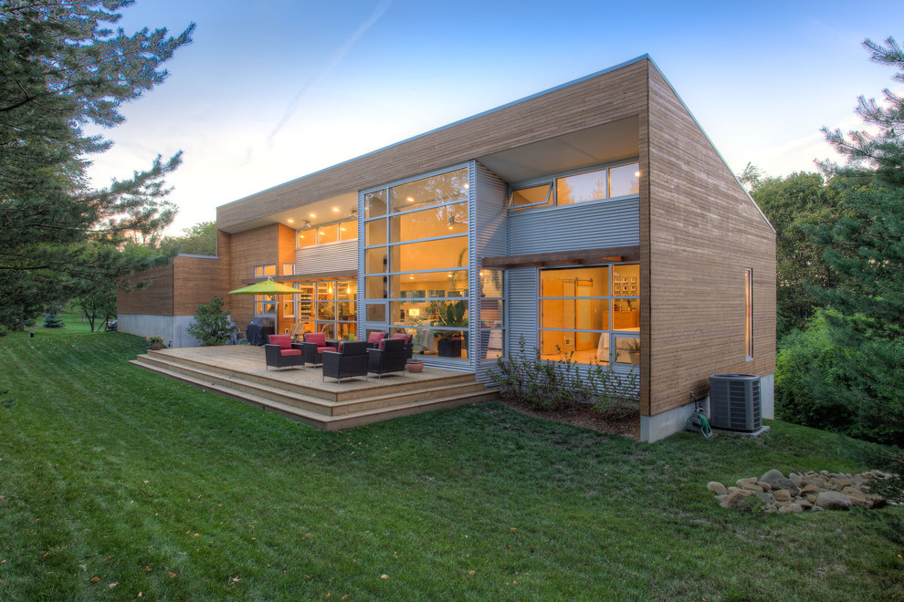 На фото: частный загородный дом в стиле модернизм с облицовкой из металла и односкатной крышей