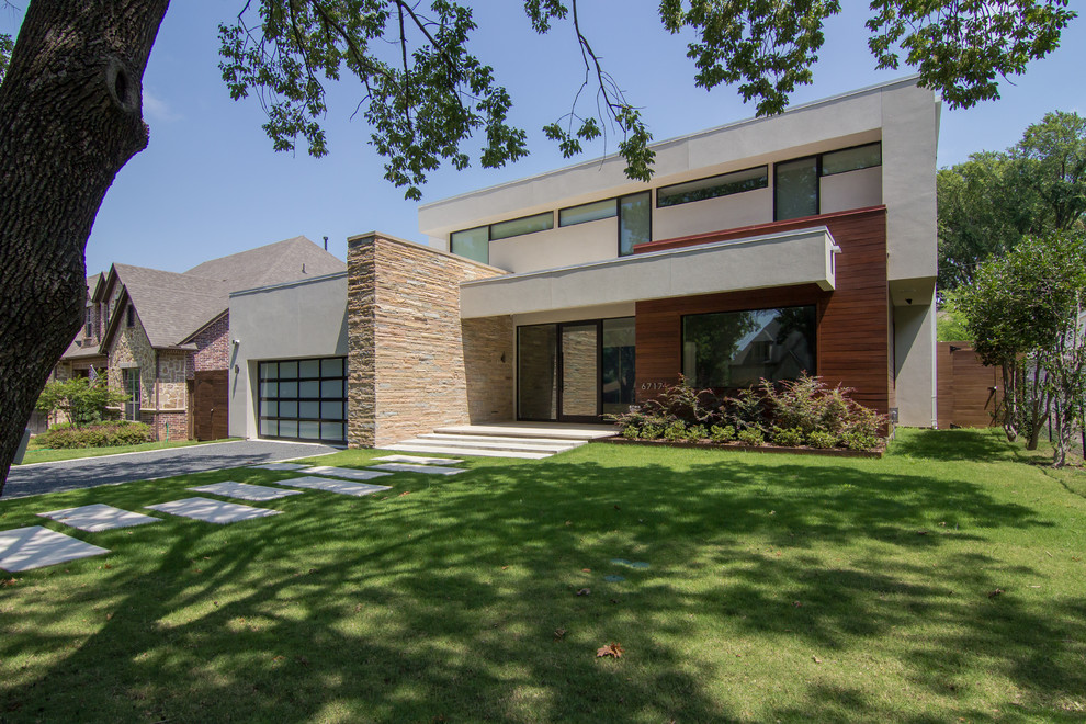 Mittelgroßes, Zweistöckiges Retro Einfamilienhaus mit Putzfassade, weißer Fassadenfarbe und Flachdach in Dallas