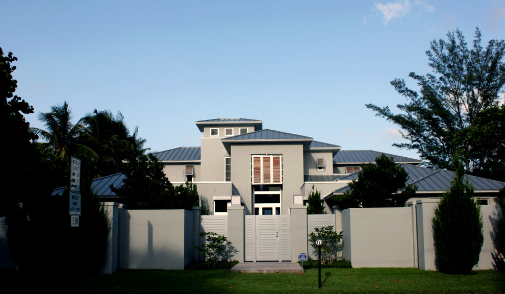 Imagen de fachada de casa gris contemporánea extra grande de dos plantas con revestimiento de adobe, tejado a la holandesa y tejado de metal