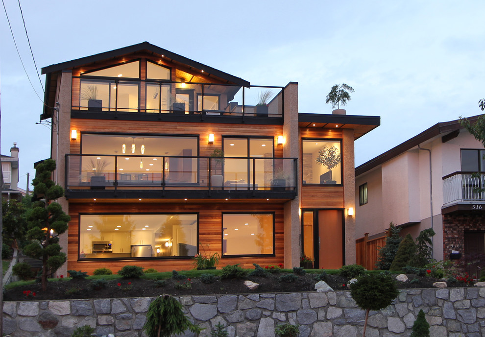 Imagen de fachada de casa marrón actual de tamaño medio de tres plantas con revestimientos combinados y tejado a dos aguas