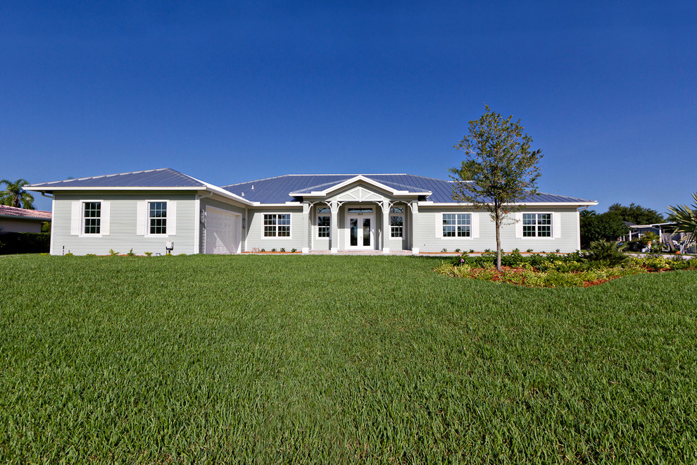 Large elegant gray one-story wood exterior home photo in Miami with a metal roof
