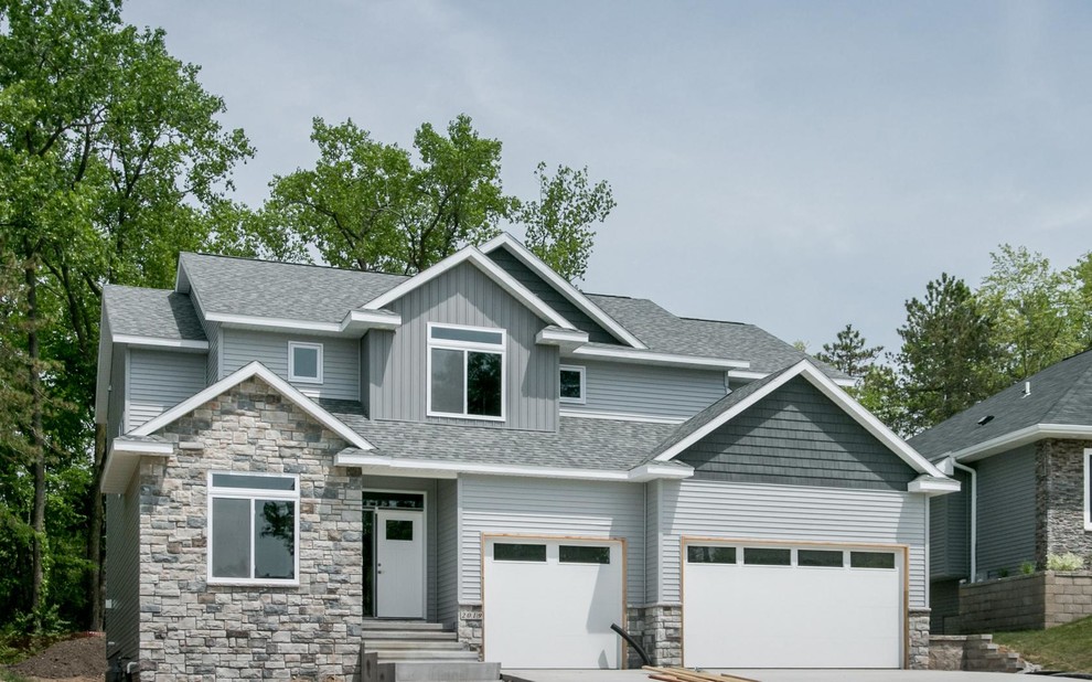 Large transitional gray two-story vinyl exterior home photo in Cedar Rapids with a shingle roof