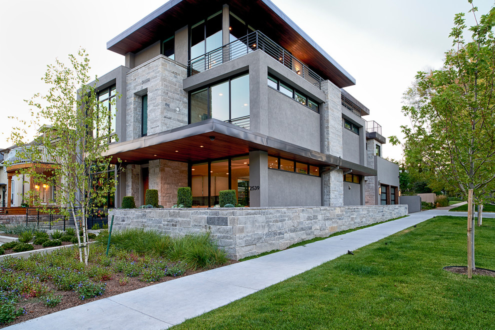 Foto de fachada de casa gris moderna de tamaño medio de tres plantas con revestimiento de piedra y tejado plano