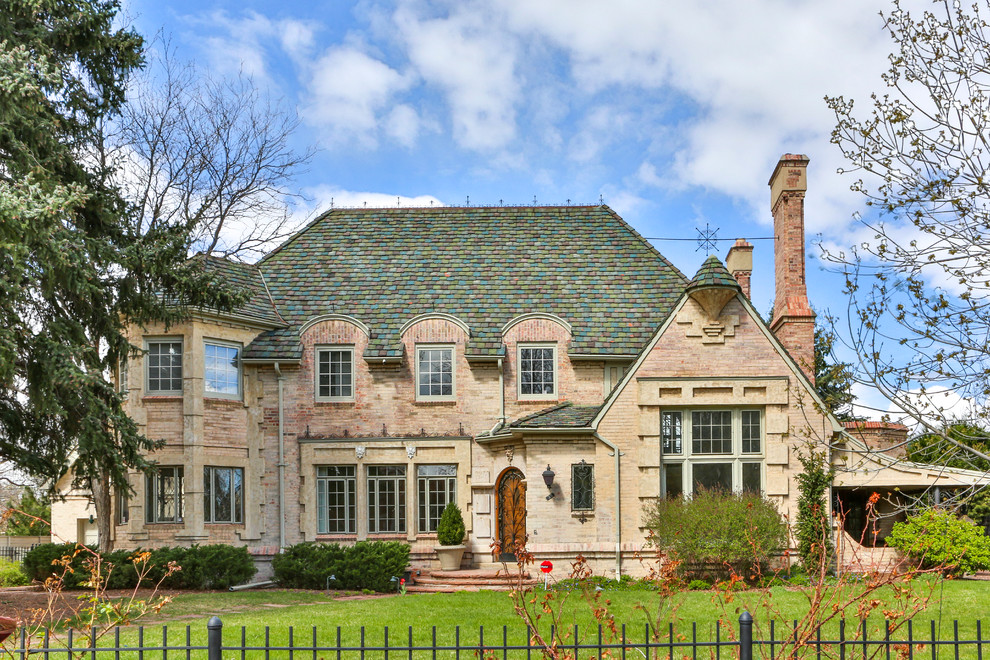 Example of a classic two-story brick exterior home design in Denver with a hip roof