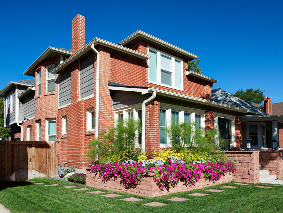 Immagine della villa rossa american style a due piani di medie dimensioni con rivestimento in mattoni e copertura a scandole