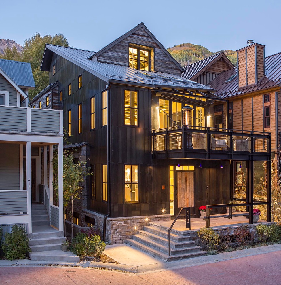Mittelgroßes, Dreistöckiges Industrial Haus mit Metallfassade, schwarzer Fassadenfarbe und Satteldach in Denver