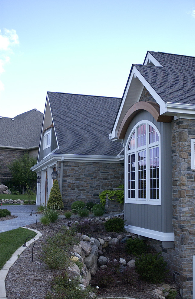Inspiration pour une grande façade de maison grise craftsman en pierre à un étage avec un toit à deux pans et un toit en shingle.