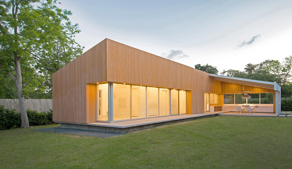 Réalisation d'une façade de maison design en bois de plain-pied.
