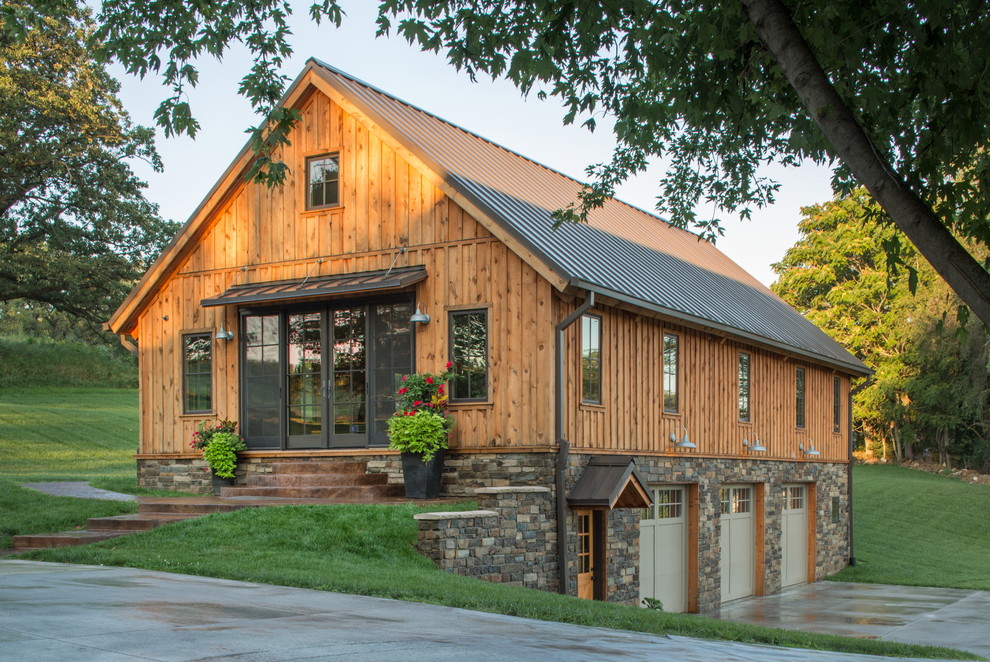 Cette photo montre une façade de maison beige nature à deux étages et plus avec un revêtement mixte et un toit à deux pans.