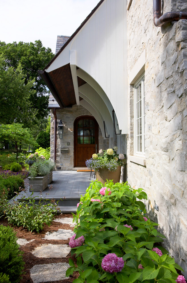 Inspiration for a traditional house exterior in Chicago with stone cladding.