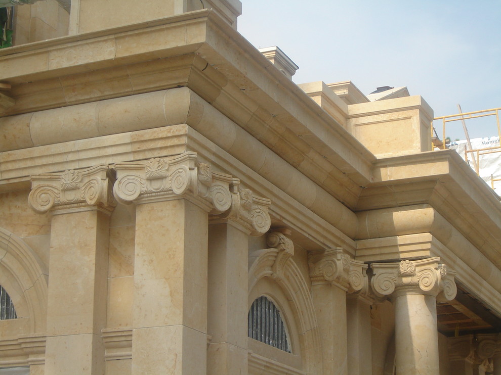 Foto della facciata di una casa beige mediterranea con rivestimento in pietra