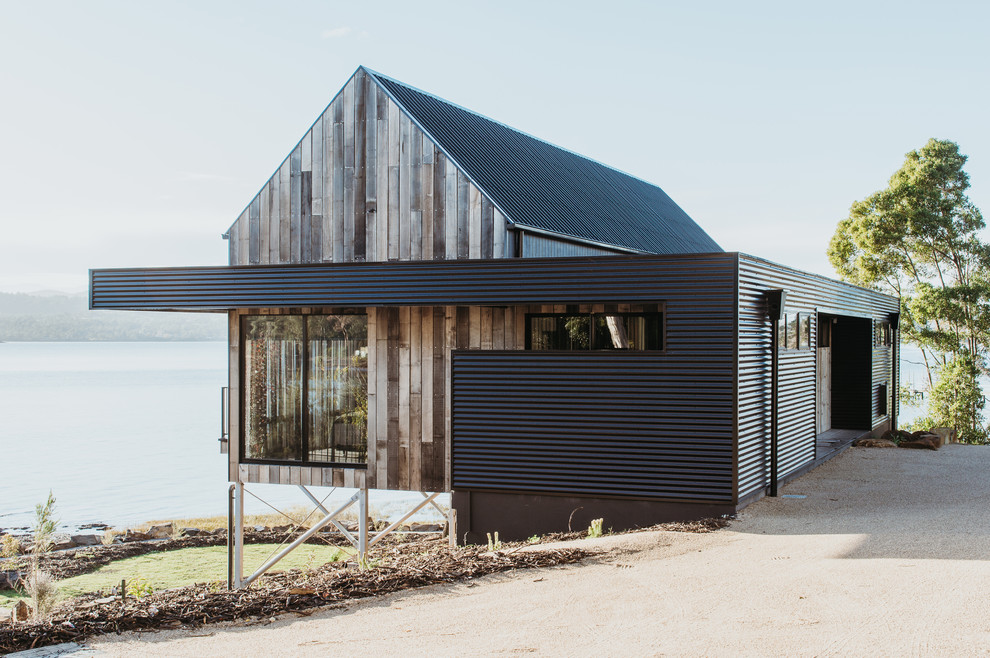 Idées déco pour une façade de maison multicolore contemporaine de plain-pied avec un revêtement mixte, un toit à deux pans et un toit en métal.
