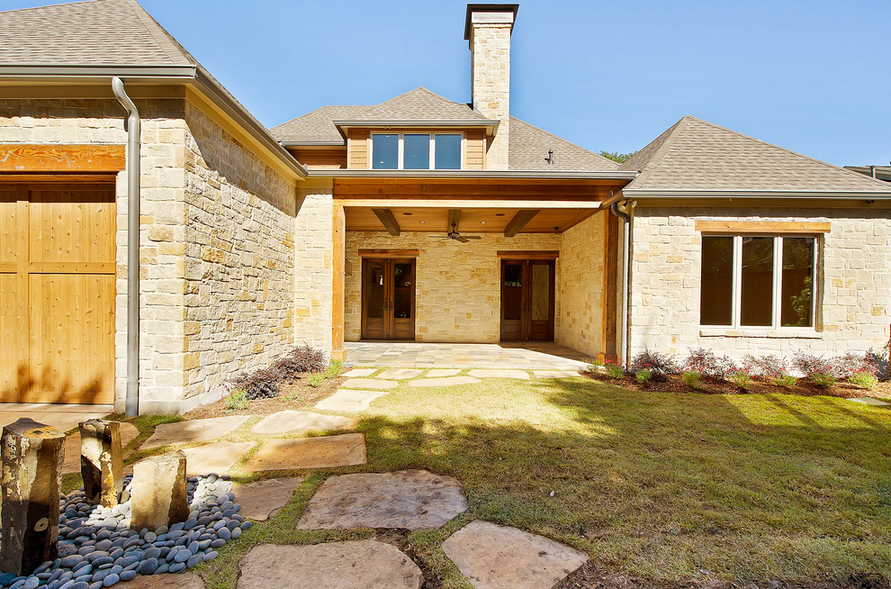 Идея дизайна: большой, двухэтажный, бежевый дом в стиле рустика с облицовкой из камня и вальмовой крышей