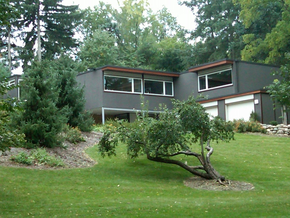 Bild på ett stort 60 tals grått hus, med två våningar och stuckatur
