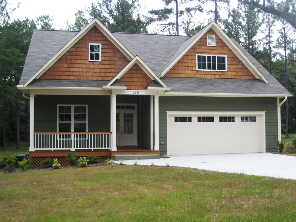 Cette image montre une façade de maison verte craftsman en panneau de béton fibré de taille moyenne et à un étage avec un toit à deux pans.