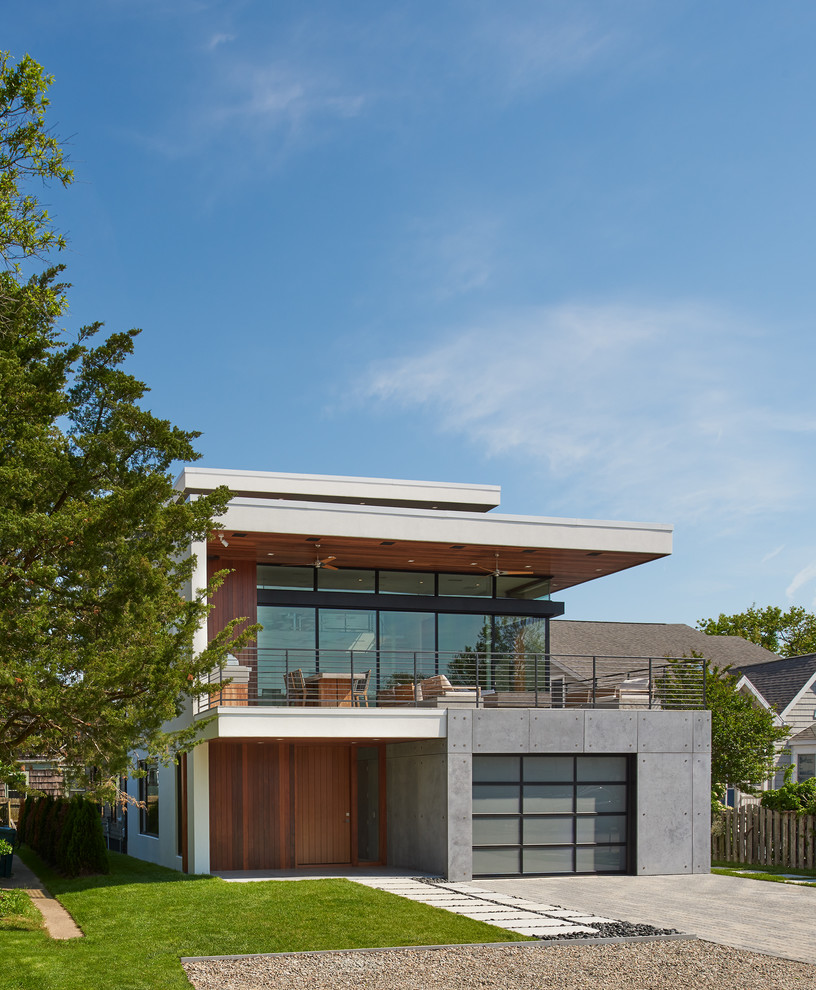 Imagen de fachada de casa multicolor actual de dos plantas con revestimientos combinados y tejado plano