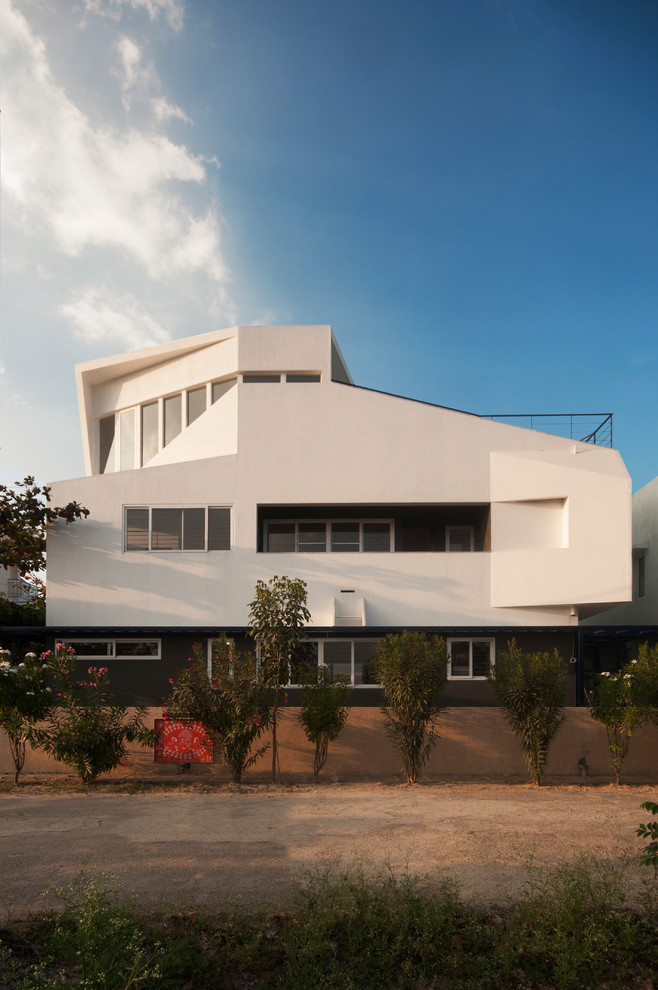 Dreistöckiges Modernes Einfamilienhaus mit Putzfassade, bunter Fassadenfarbe und Flachdach in Bangalore