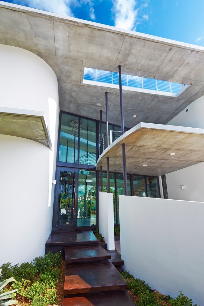 На фото: двухэтажный, белый дом среднего размера в стиле модернизм с облицовкой из бетона и плоской крышей с