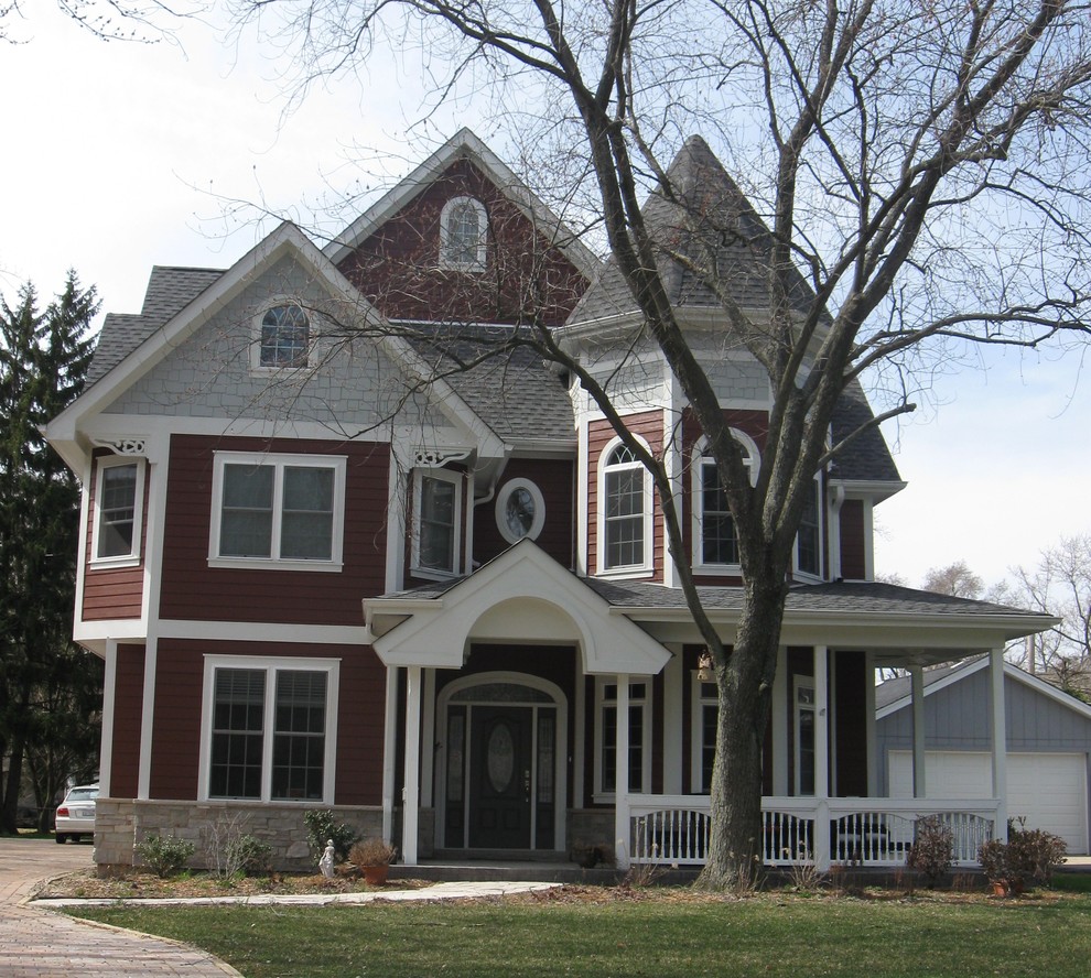 Пример оригинального дизайна: большой, трехэтажный, красный частный загородный дом в викторианском стиле с облицовкой из ЦСП, двускатной крышей и крышей из гибкой черепицы